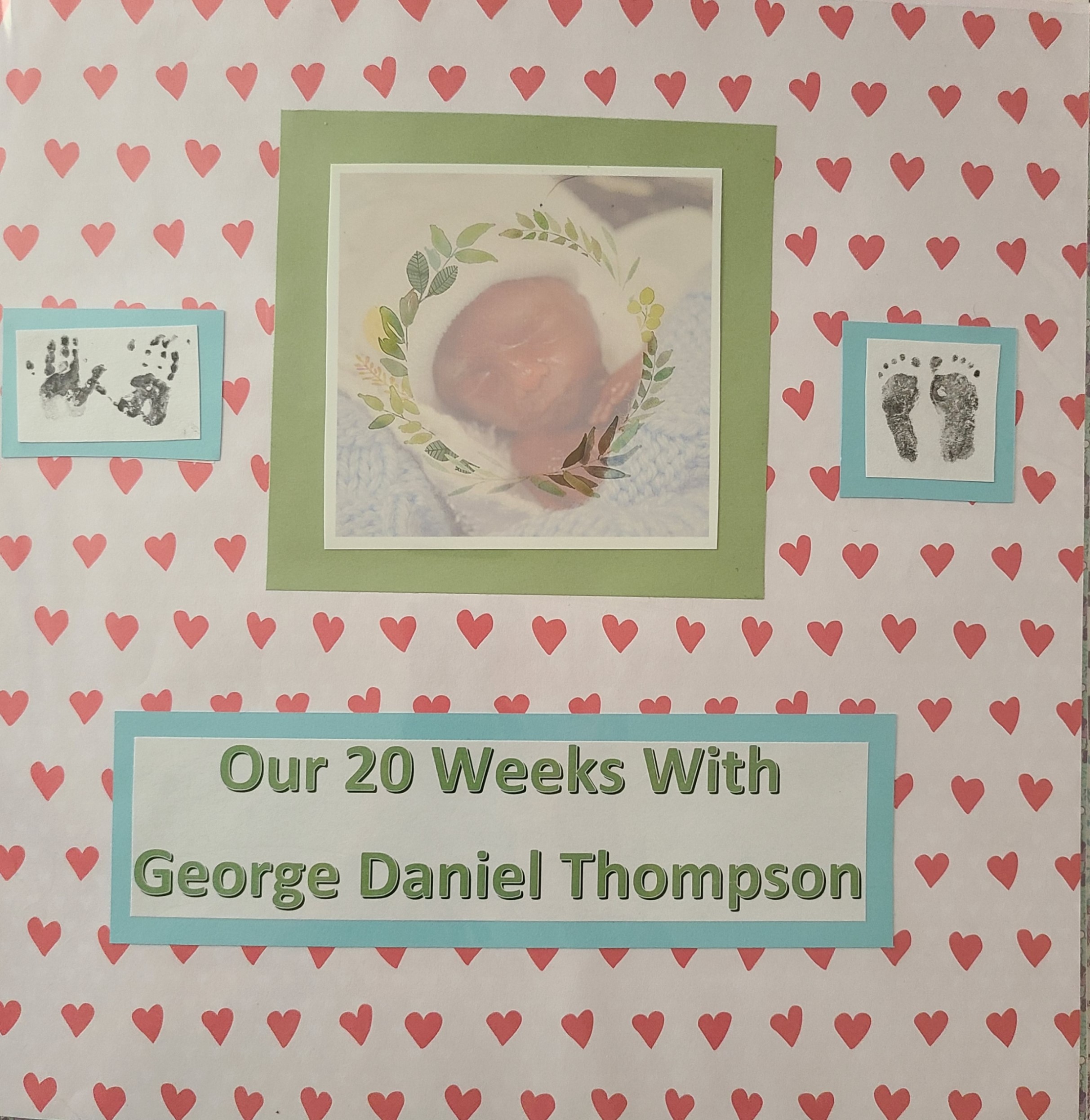 scrapbook cover with a central image of a tiny baby's head (in a small white knit cap) and hands, wrapped in a light blue blanket. To the right and left are tiny hand and footprints. Below is the title "Our 20 Weeks With George Daniel Thompson".